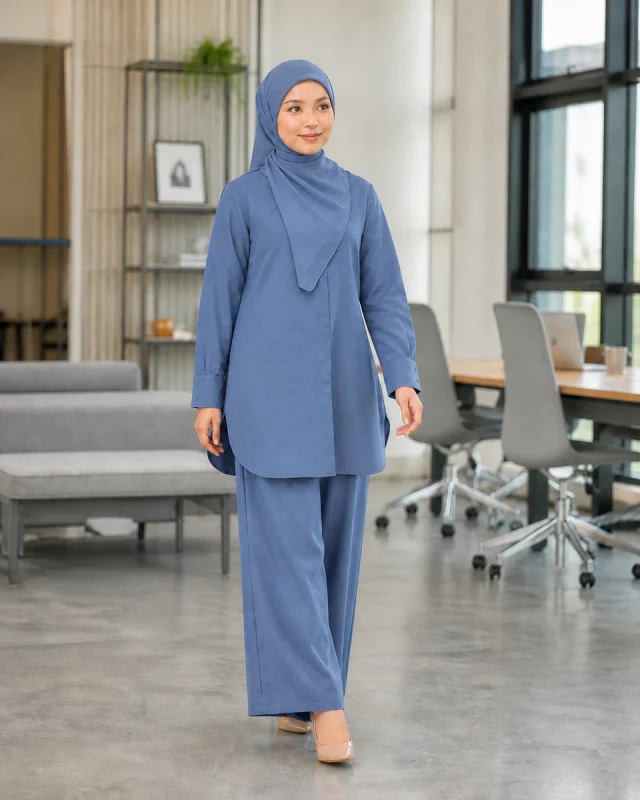 Model memakai Set Elora Muslimah warna Denim Blue di ruang kerja moden.